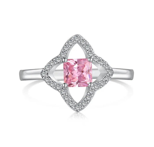 This is a 4 leaf clover like silver plated ring with miniature cz embroidery diamonds around the clover petals and a mini pink central square diamond inside the clover at the front/top of the ring 