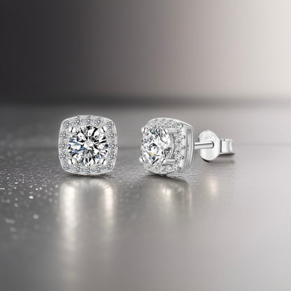 Curved square studs with silver plating. There is a white central circular crushed diamond with miniature decorative white diamonds going around it on the plating of the stud pair 