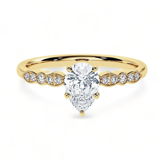 A gold plated ring with a mini white pear shaped diamond as the central piece followed by very miniature white embroidery diamonds to each side of the pear central piece. The miniature diamonds only go to the sides partially, not all around the band so the gold band is still visible particularly at the back of the ring 